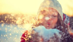 woman blowing snow in the air